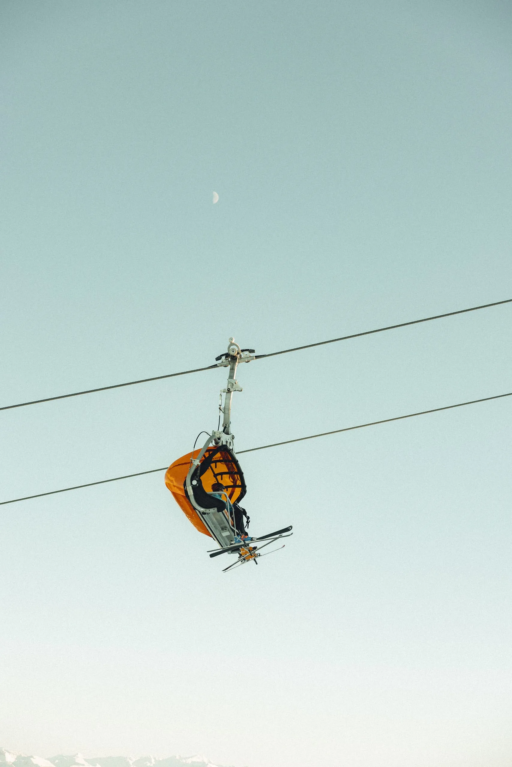 Seilbahn mit orangefarbener Gondel über den Alpen