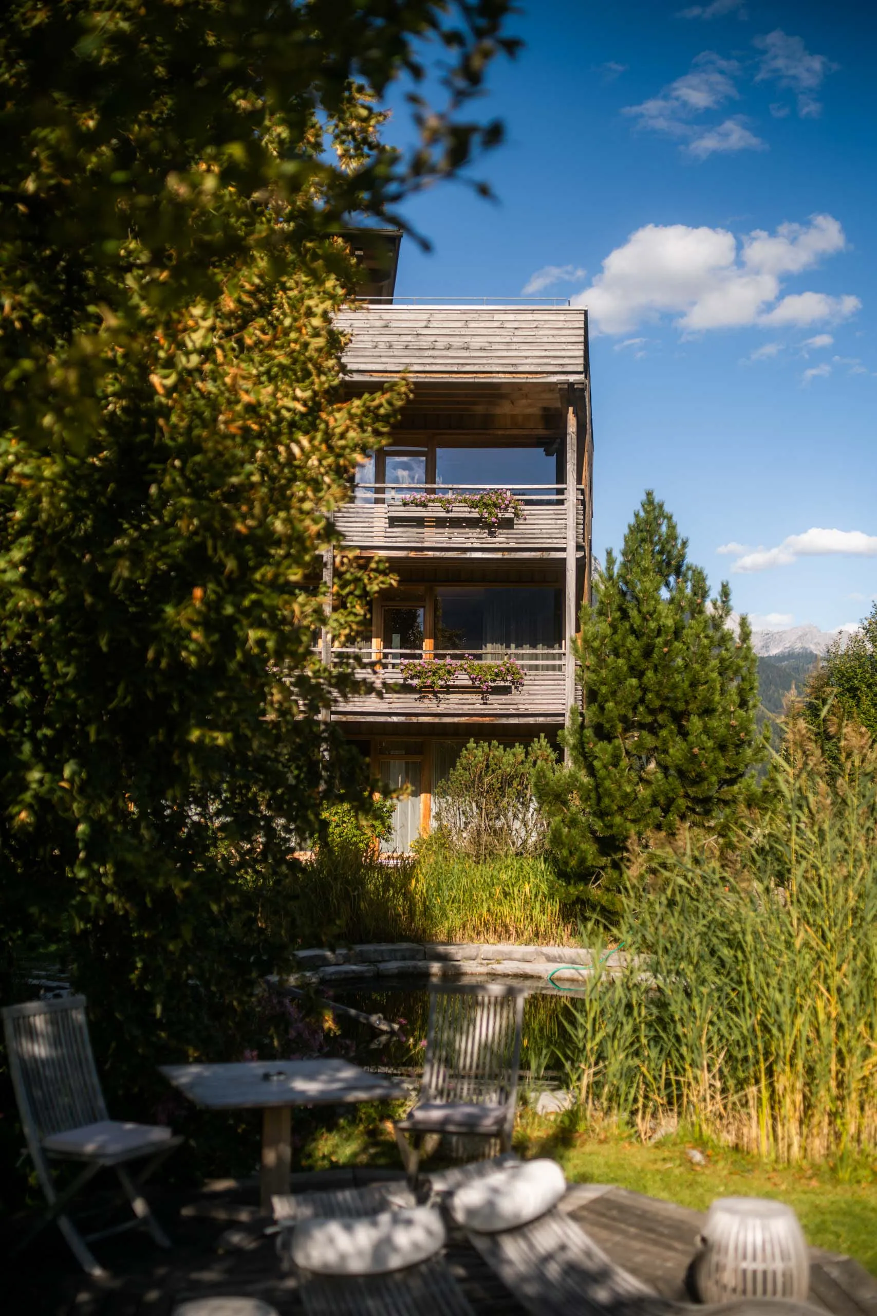 Holzhotel Forsthofalm in Leogang, umgeben von Natur und blauem Himmel