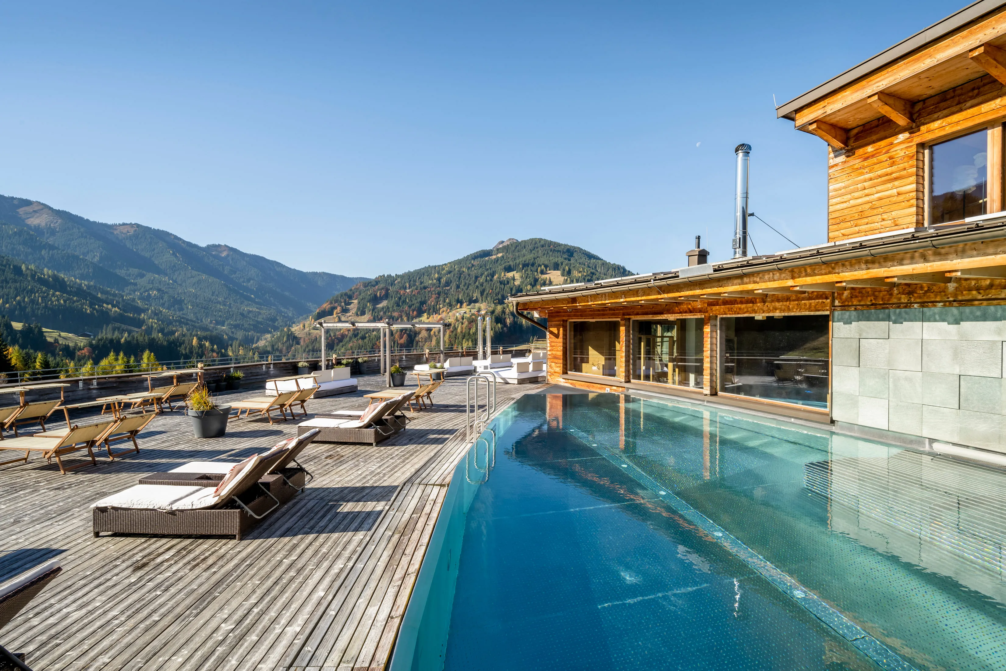 Holzhotel Forsthofalm mit Blick auf die Berge und einem Außenpool