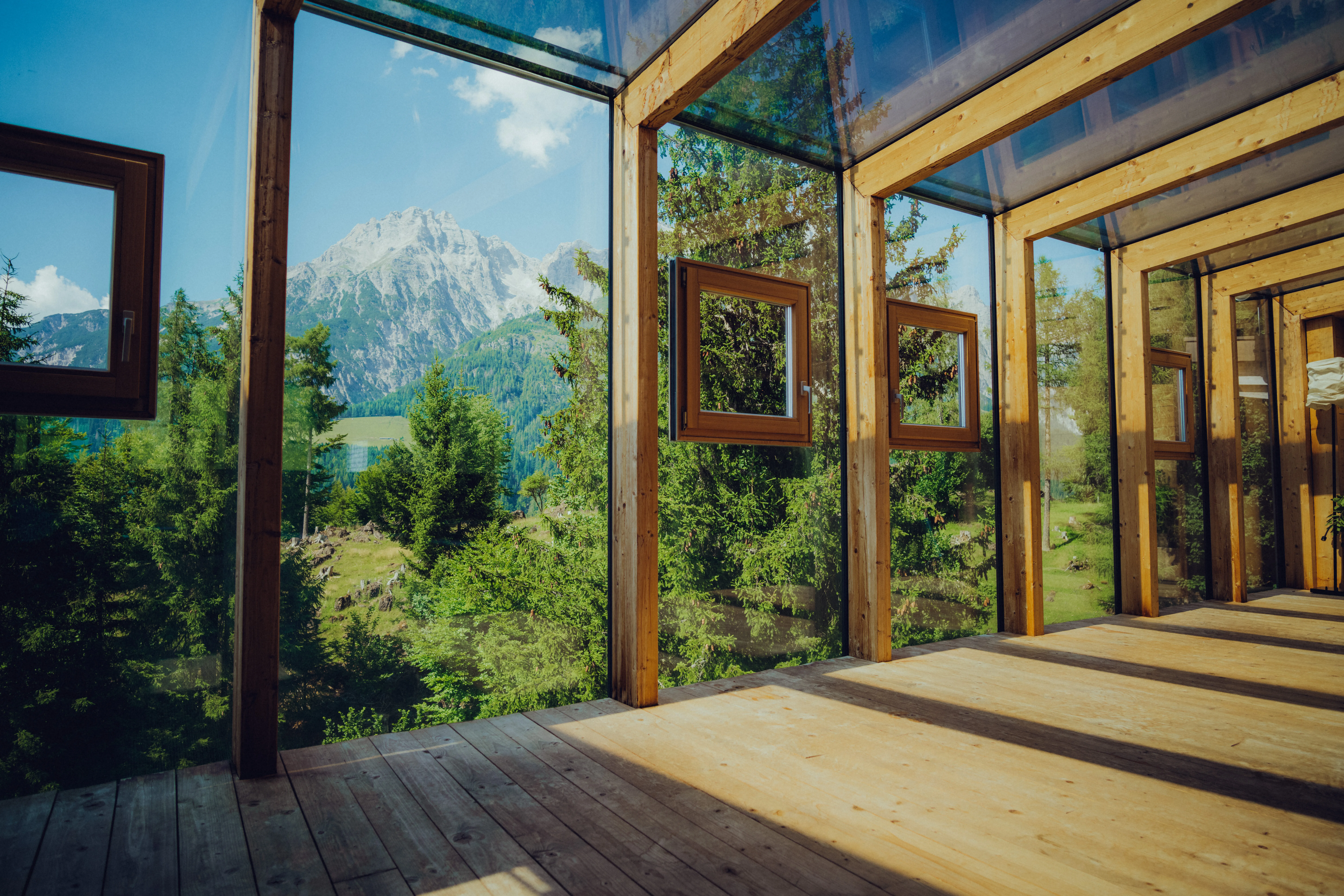 Glaswände mit Bergblick und Holzfußboden