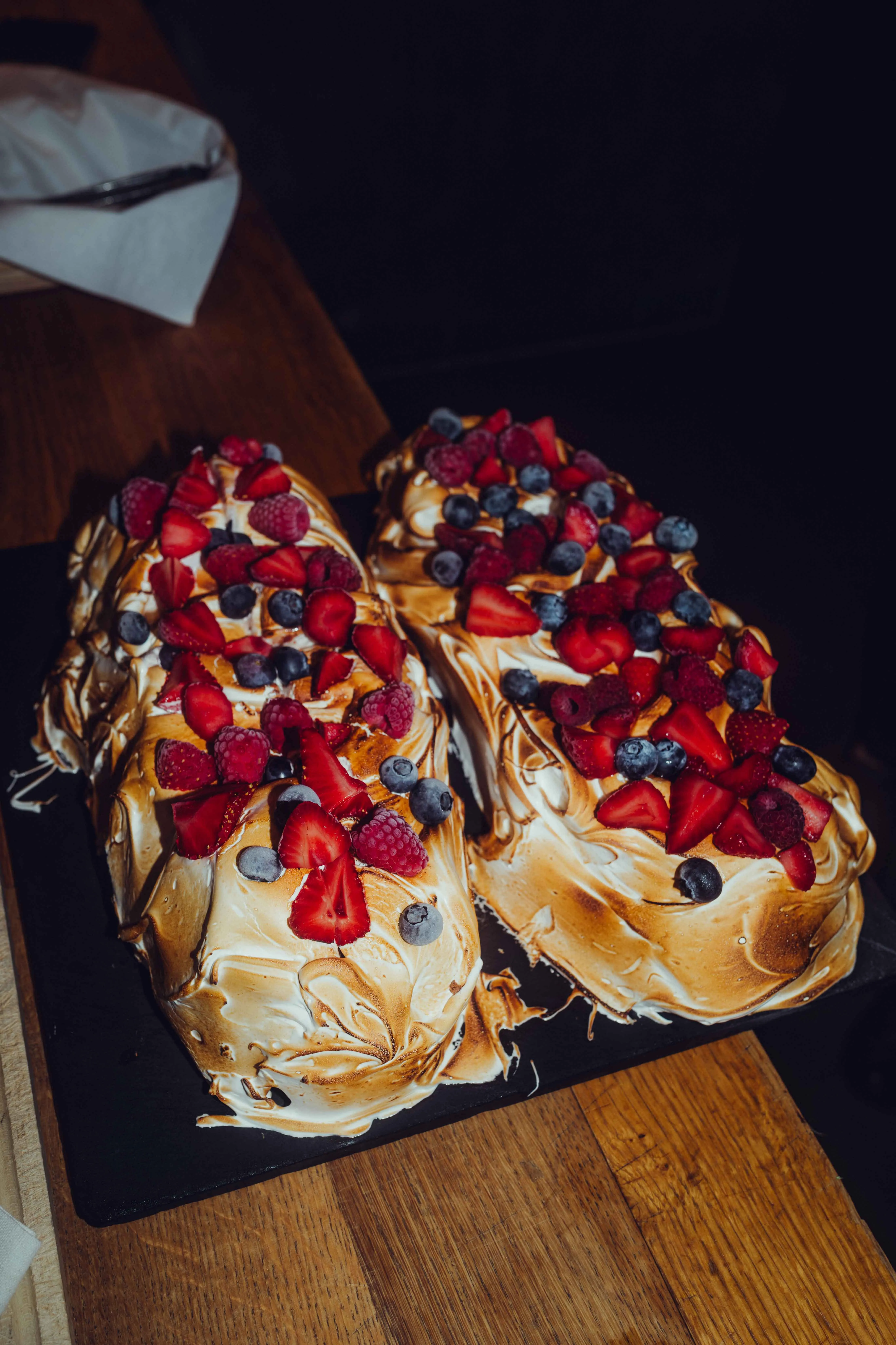 Zwei bunte Desserts mit Früchten auf einem Holzbrett