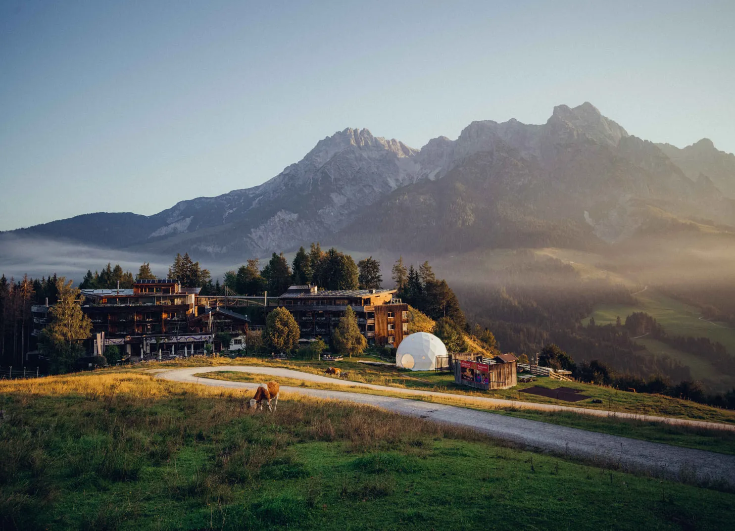 Holzhotel Forsthofalm mit Bergen im Hintergrund
