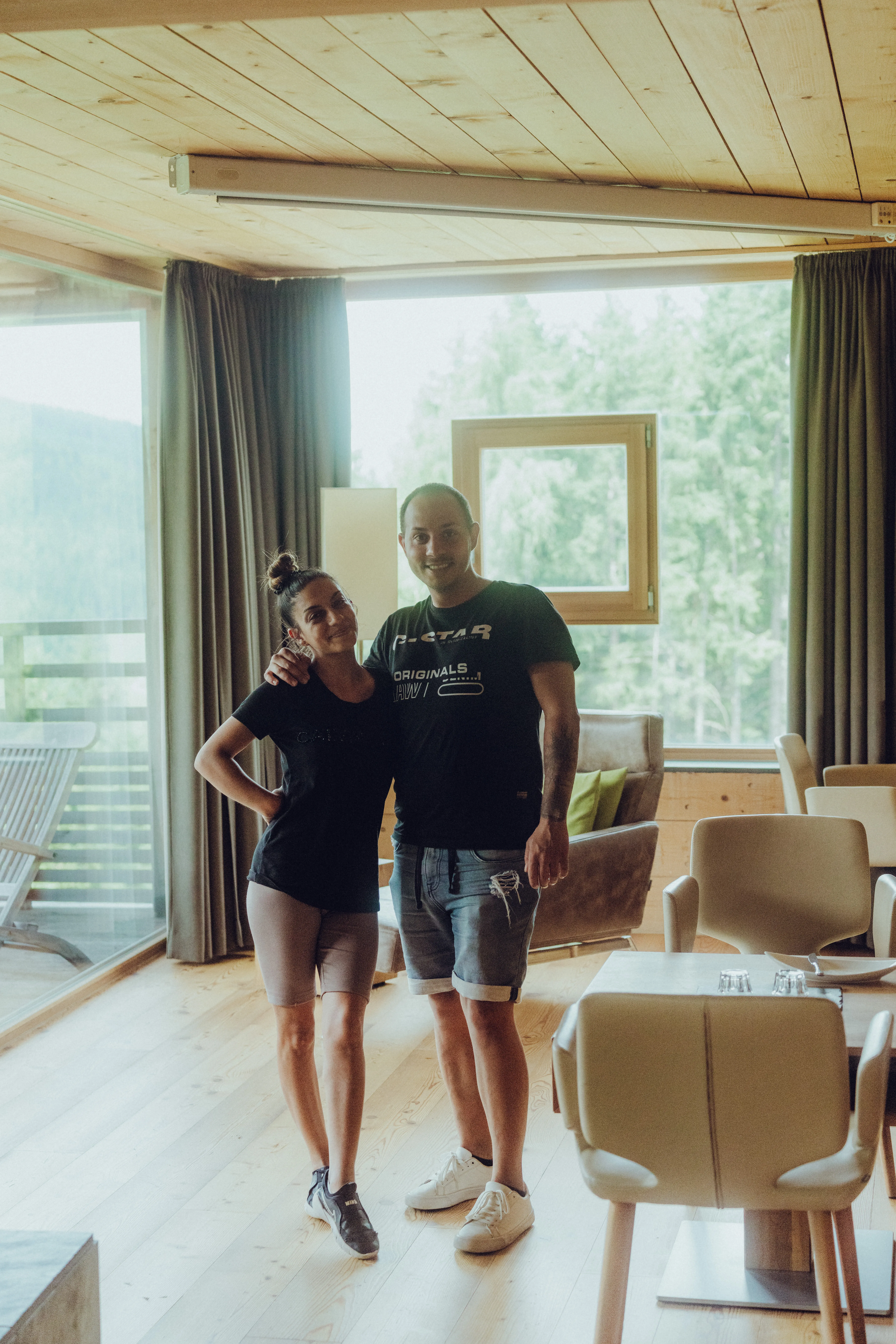 Paar steht in einem modernen Raum mit Holzdecke