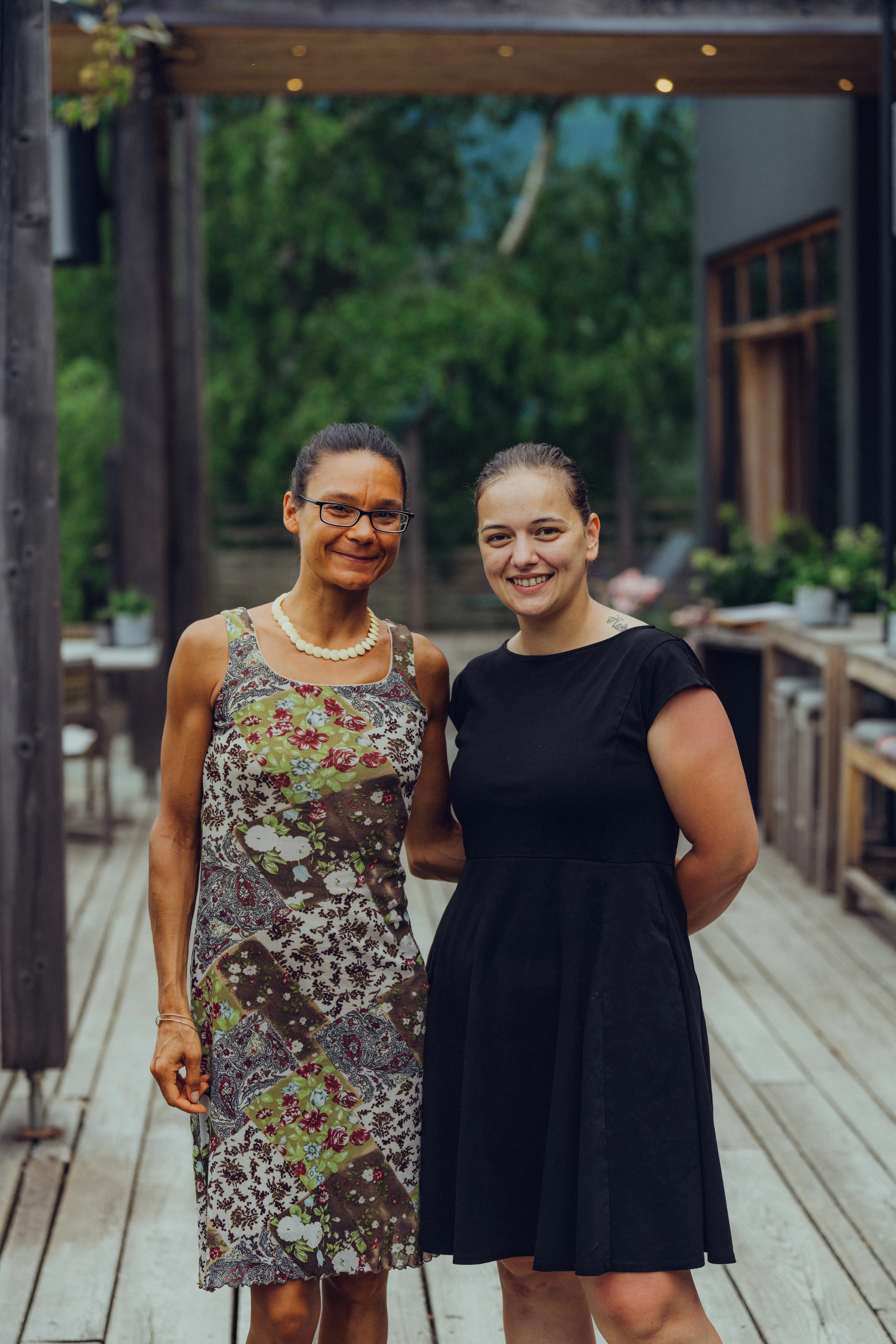 Zwei Frauen stehen auf einer Terrasse im Freien.